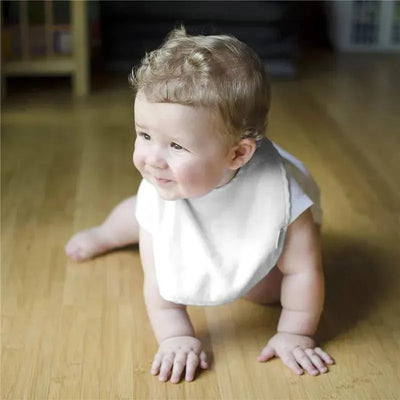 A happy baby crawling on a wooden floor, wearing a white Stay-Dry bib.