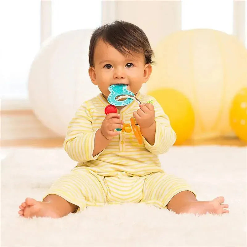 Infantino Cool & Chew Teether Keys held by a baby sitting on a soft surface, wearing striped pajamas, with bright balloons in the background.