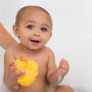 Smiling toddler in a bath holding a yellow rubber duck, surrounded by bubbles.