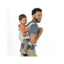 Infantino Flip 4-in-1 Light & Airy Convertible Carrier in teal, worn by a smiling father, carrying a toddler on his back.