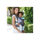 Mother wearing an Infantino Flip Advanced 4-in-1 Convertible Carrier in light grey, holding a baby dressed in light purple.