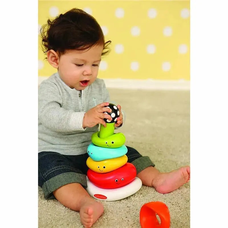 Child stacking colorful rings on a base, engaging with the Infantino Funny Faces Ring Stacker toy.