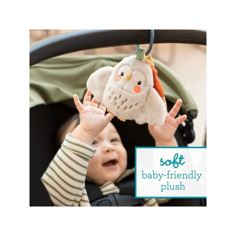 Soft baby-friendly plush toy, Olive the Owl, being reached for by an excited baby in a stroller.