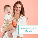 Soft silicone 9 oz cream tumbler held by a smiling mother with a baby, highlighting its leak-resistant straw feature.
