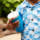 Soft silicone blue tumbler with a white lid held by a child wearing a blue and white checkered shirt.