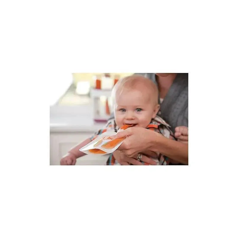 Baby holding an Infantino Squeeze Pouch, smiling while being assisted by an adult.