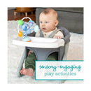 Infantino Stick & Spin Pal, Raccoon toy attached to a baby seat with a sitting baby engaging with it.