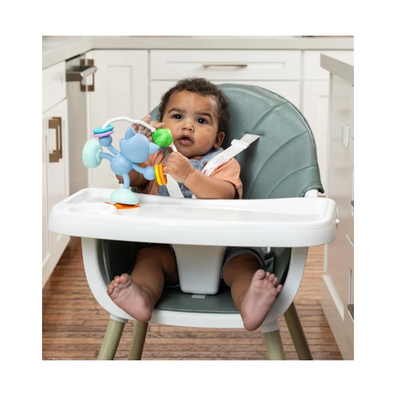 Infantino Stick & Spin Pal Raccoon toy held by a toddler in a high chair, featuring colorful attachments and a playful design.