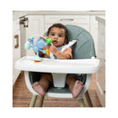 Infantino Stick & Spin Pal Raccoon toy held by a toddler in a high chair, featuring colorful attachments and a playful design.