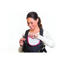 A woman is smiling while adjusting the Infantino Swift Classic Baby Carrier in black, highlighting its practical design.