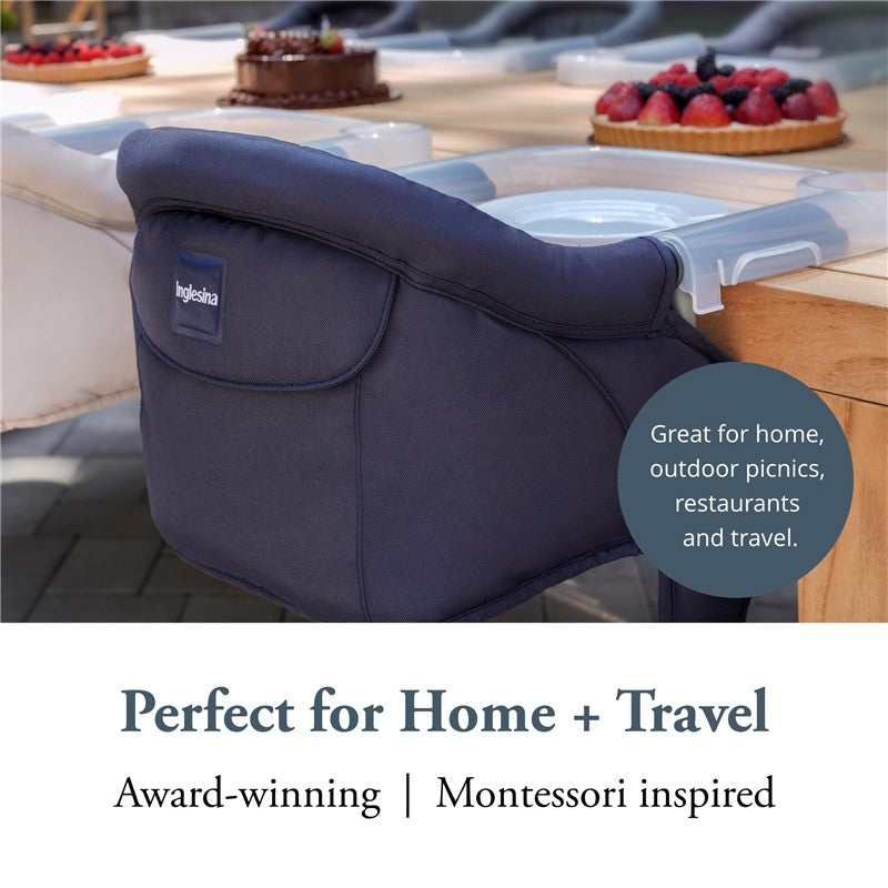 Navy Inglesina Fast Table Chair attached to a table, promoting its use for home, travel, and outdoor settings.