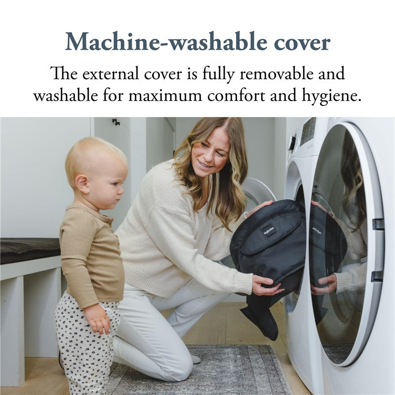 Mother placing a removable black cover into a washing machine while a child watches, highlighting machine-washable features.