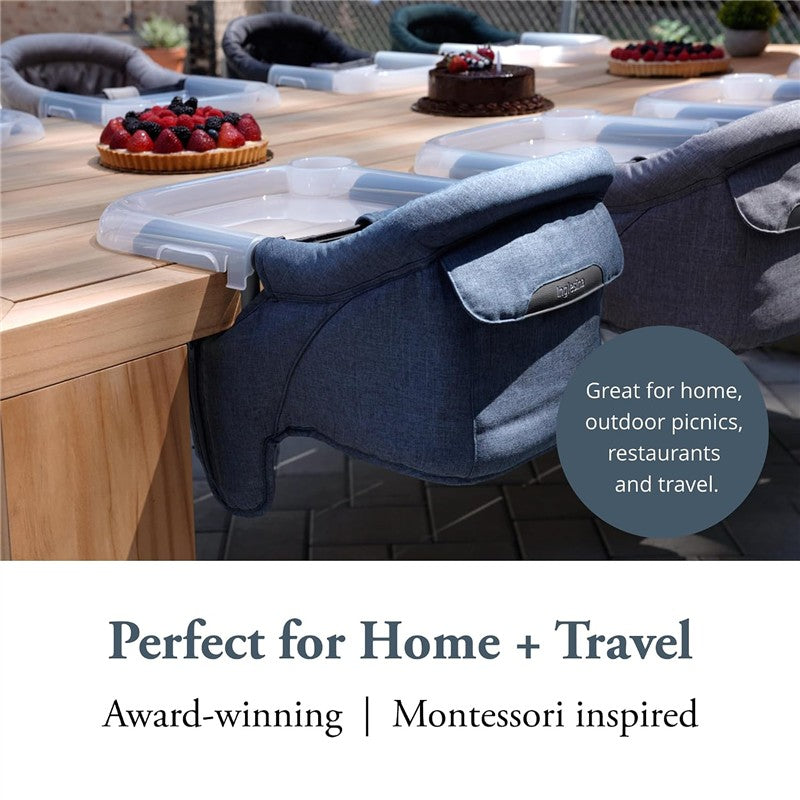 Inglesina Fast Table Chair in Slate Blue Melange attached to a wooden table, showcasing its suitability for home, outdoor, and travel use.