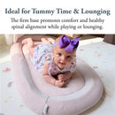 Infant on a Inglesina Welcome Pod Lounger in Balance Green, promoting comfort and spinal alignment during tummy time.