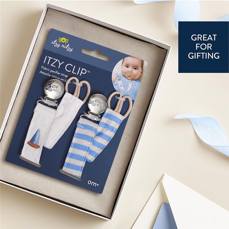 Fabric pacifier straps in boat stripe and solid white, featuring a sailboat design, packaged for gifting.