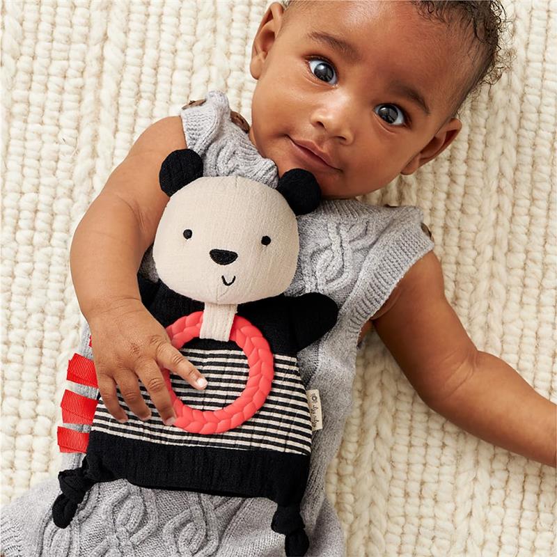 Bitzy Crinkle Sensory Toy Panda held by a baby, featuring crinkle sound and a textured ring for tactile exploration.