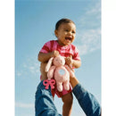 Smiling baby in a pink outfit holds a bunny sensory toy with a mirror, being lifted up by an adult against a blue sky.