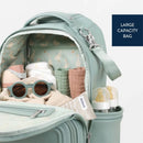 Light green Itzy Ritzy Boss Plus™ Backpack Diaper Bag, open to reveal organized items like bottles, sunglasses, and blankets.
