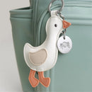 Backpack diaper bag keychain features a plush duck design with a silver tag, attached to a light green bag.
