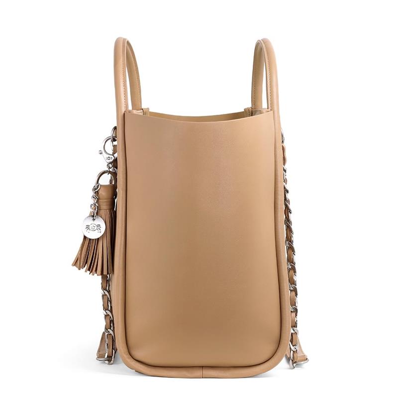 Chai Latte Itzy Ritzy Boss Tote™ Diaper Bag featuring a modern design, chain detailing, and a tassel accessory.