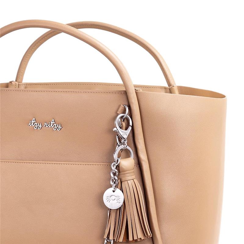 Chai Latte Itzy Ritzy Boss Tote™ diaper bag featuring a silver charm and tassel detail.