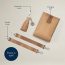 Chai Latte diaper bag accessories: changing pad, tassel charm, and stroller straps, featuring modern styling.