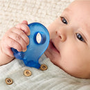 Baby holding a blue octopus-shaped teether while sitting on a textured surface, wearing a light shirt with buttons.