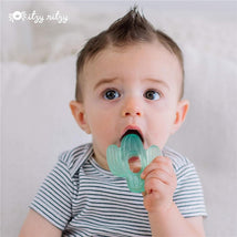 Baby with a spiky hairstyle sucking on a light green cactus-shaped teether, looking curiously at the camera.