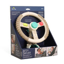 Taupe Itzy Ritzy Driver Travel Steering Wheel with interactive fidgets, designed for infants 6 months and older, packaged in a decorative box.