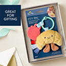 Plush Itzy Pal teething toy with a smiling croissant design and silicone strawberry teether, packaged for gifting.
