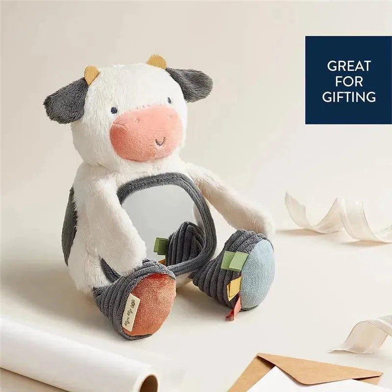 A soft cow-shaped mirror toy with colorful tags and plush fabric, ideal for infants and gift-giving.