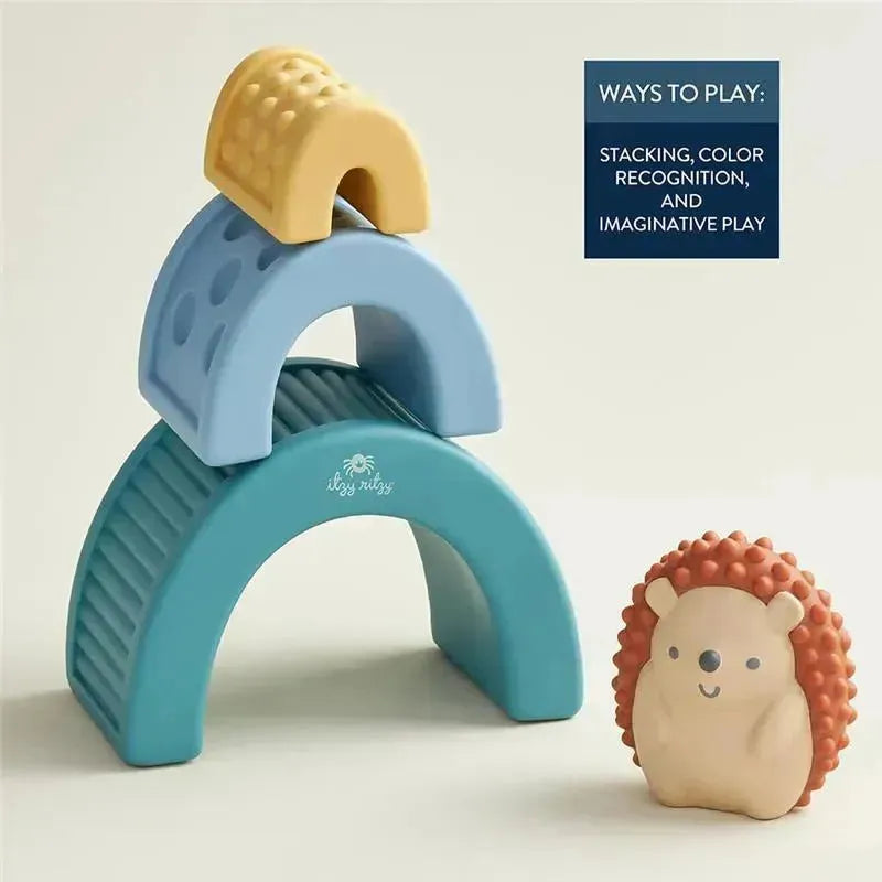 Colorful Itzy Ritzy Itzy Blocks™ stacked in a playful arrangement with a smiling hedgehog toy beside them.