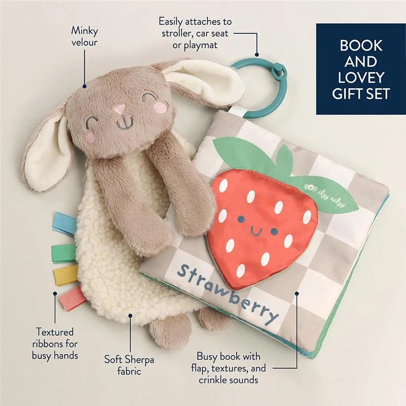 Bunny lovey with minky velour and textured ribbons alongside a strawberry-themed busy book, both for infants.