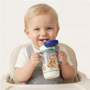 Toddler sitting in a high chair, smiling while holding the Itzy Ritzy Itzy Sips Straw Cup with a blue lid and bear design.