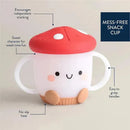 Mushroom-shaped Itzy Snack Cup™ with a smiling face, easy-to-grasp handles, and a no-slip base, promoting mess-free snacking.