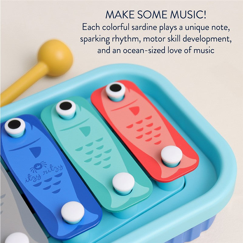 Colorful sardine-shaped xylophone with a mallet, promoting motor skills and musical play, featuring three colored keys and playful design.