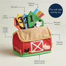 Sensory scarf toy shaped like a barn, featuring vibrant colors, textured ribbons, and crinkle sounds, promoting counting and play.
