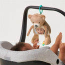 Sensory tummy time toy mirror in the shape of a bear, featuring a reflective surface for infants, shown with a baby reaching towards it.
