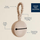 Silicone pacifier case in toast color with flexible strap, capable of holding two pacifiers and easily attaching to bags.