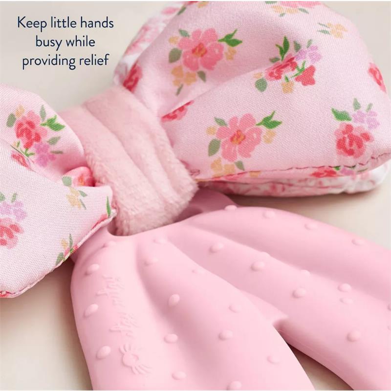 Silicone sensory teether bow in pink with floral fabric, designed to keep little hands busy while providing relief.