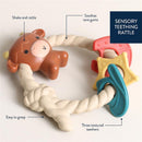 Silicone teether and rattle in the shape of a Highland cow with three textured teething surfaces, designed for soothing sore gums.