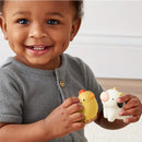 Smiling child holds a yellow chicken and a white cow toy from the Itzy Ritzy Spill and Fill Activity Toy set.