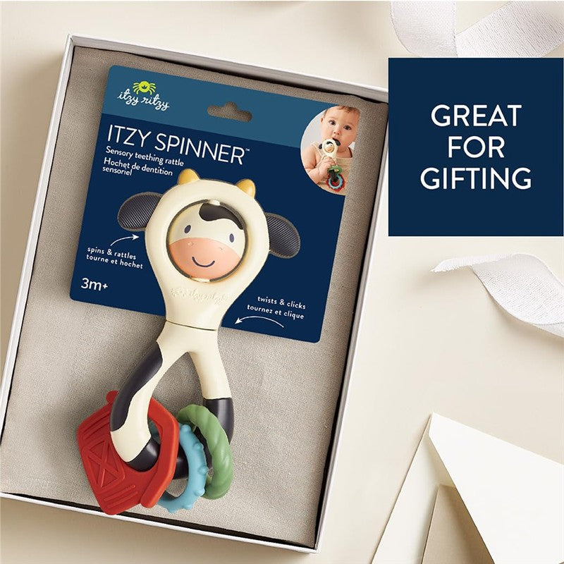 Spinner rattle in cow shape with colorful rings, packaged for gifting; suitable for ages 3 months and up.