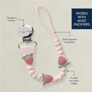 Strawberry-themed silicone pacifier clip with a metal clip, designed to attach securely to pacifiers.
