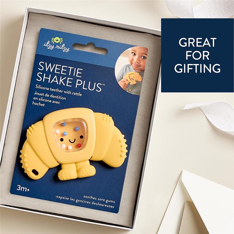 Silicone teether and rattle toy shaped like a croissant, designed to soothe sore gums for babies 3 months and older.