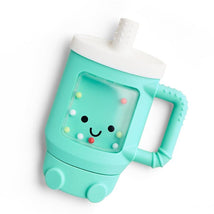 Teething rattle toy shaped like a tumbler, featuring a smiling face, colorful beads, and a green body with a white lid.