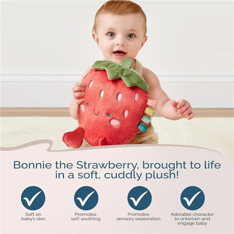 Baby holds a plush strawberry character named Bonnie, promoting sensory exploration and self-soothing.