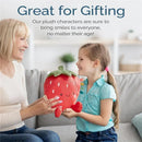 A girl and an older woman smile while holding a red strawberry-shaped plush toy with a happy face.