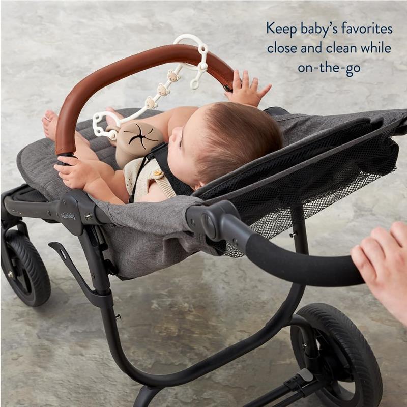 Itzy Ritzy Toy & Snack Cup Strap attached to a stroller, keeping baby’s toys secure while showing a baby enjoying the ride.