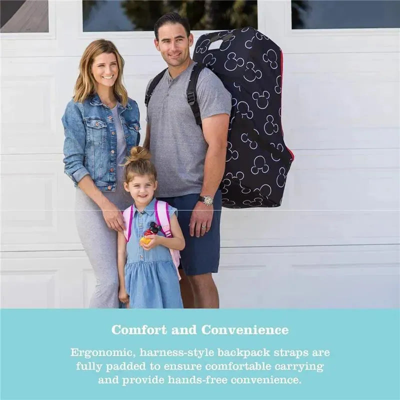 Family standing in front of a garage with a Mickey Mouse-themed padded car seat travel bag. A child holds a toy and wears a backpack.